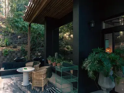 a patio with a table and chairs and plants at The Little Black Box in Somerset West
