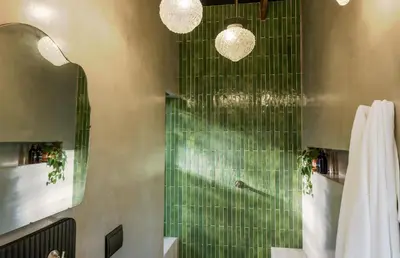 a bathroom with a shower with green tiles at The Little Black Box in Somerset West