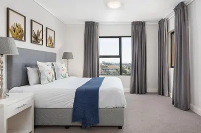 a bedroom with a large bed and a large window at LuxeStay 2-Bed Century City Gem in Cape Town