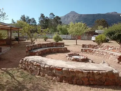 a row of stone benches in a yard at A Rustic and Reflective Nature Getaway in Greyton in Greyton