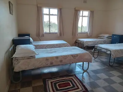 a room with three beds and two windows at A Rustic and Reflective Nature Getaway in Greyton in Greyton