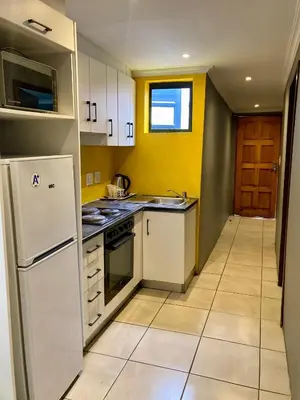 a kitchen with white appliances and yellow walls at Unit 3 TraversHub Sleeps 6 Self-Catering Group Belhar, CT in Belhar