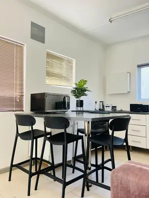 a kitchen with a table with chairs and a microwave at Sunny Snooze Holiday Home in Goodwood