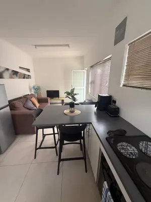 a kitchen and a living room with a table in a kitchen at Sunny Snooze Holiday Home in Goodwood