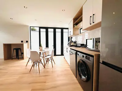 a kitchen and dining room with a table and a dishwasher at Modern Scandinavian Luxury Apartment in Hermanus
