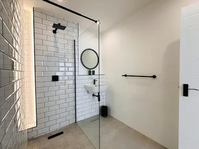 a bathroom with a glass shower and a sink at Modern Scandinavian Luxury Apartment in Hermanus