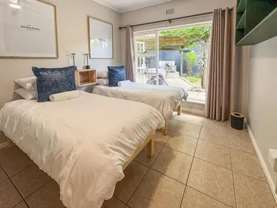 two beds in a room with a window at Spacious Holiday house with swimming pool in Blomtuin