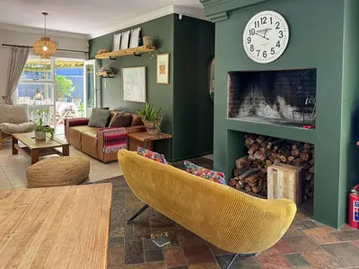 a living room with a clock above a fireplace at Spacious Holiday house with swimming pool in Blomtuin