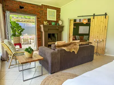 a living room with a couch and a fireplace at Spacious Holiday house with swimming pool in Blomtuin