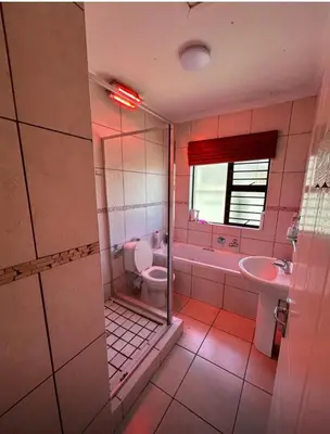 a bathroom with a toilet and a sink and a tub at Holiday Home in Cape Town
