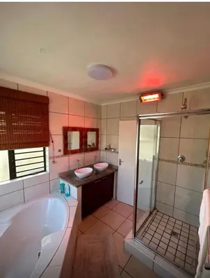 a bathroom with a tub and two sinks and a shower at Holiday Home in Cape Town