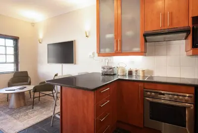 a kitchen with wooden cabinets and a black counter top at 9 at Huis Piron - Location Stellies Central in Stellenbosch
