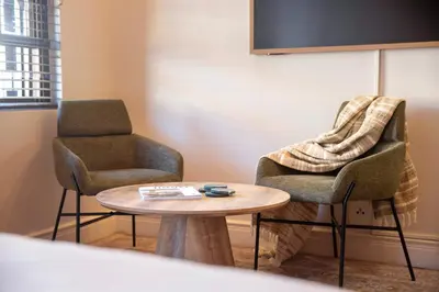 two chairs and a table in a room at 9 at Huis Piron - Location Stellies Central in Stellenbosch