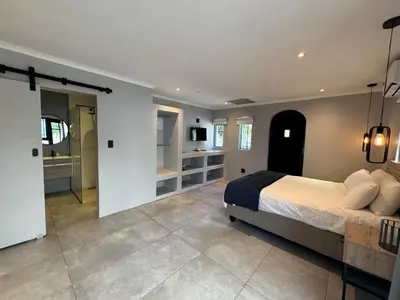 a bedroom with a large bed and a bathroom at One-Bedroom apartment in Somerset West in Helderberg