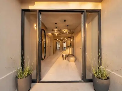 a hallway with two potted plants and a glass door at Guesthouse Ubuntu - Stellenbosch in Stellenbosch