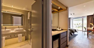 a bathroom with two sinks and a large mirror at Krystal Beach Hotel in Gordonʼs Bay