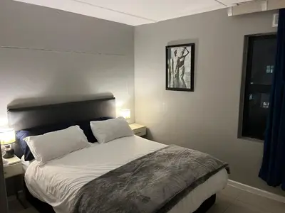 a bedroom with a large bed with two pillows at Minimalist 2 bed 1 full bathroom in Cape Town
