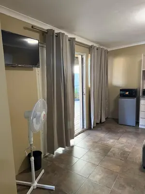 a living room with a fan and a window at Kabana Guest House Morgenzicht in Windsor Park