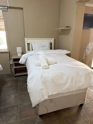 a bedroom with a white bed with two pillows on it at Kabana Guest House Morgenzicht in Windsor Park
