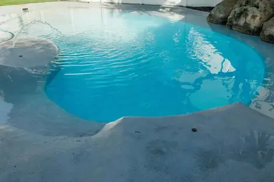 a pool of blue water with a shark in it at Beach House in Sunset Beach in Cape Town