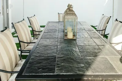 a long table with chairs and a lantern on it at Beach House in Sunset Beach in Cape Town