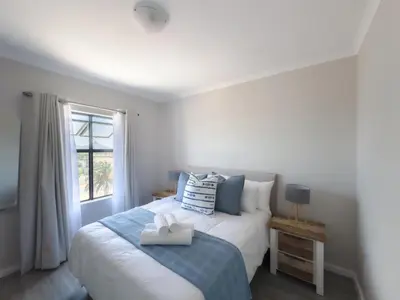 a bedroom with a bed and a window at Manchester Heights Deluxe Apartments in Cape Town