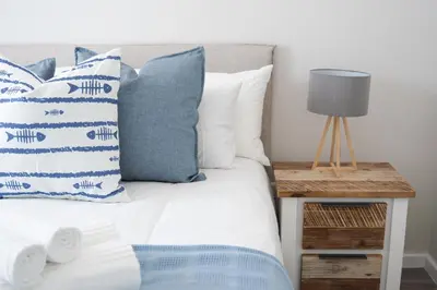 a bedroom with a bed with blue and white pillows at Manchester Heights Deluxe Apartments in Cape Town