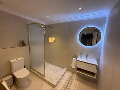 a bathroom with a toilet and a sink and a mirror at Luxe Stay Somerset West 4 in Somerset West