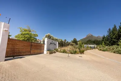 a road with a fence on the side of a building at Winelands Luxury Accommodation in Stellenbosch