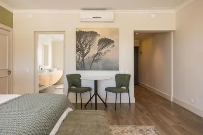 a bedroom with a bed and a table and chairs at Winelands Luxury Accommodation in Stellenbosch