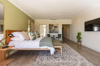 a bedroom with a large bed and a table at Winelands Luxury Accommodation in Stellenbosch