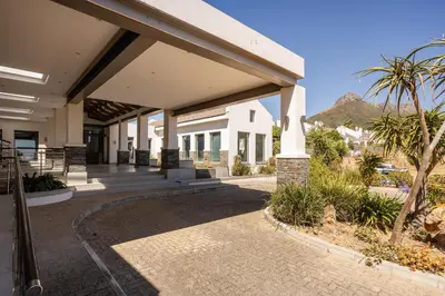 a building with a porch with a palm tree at Winelands Luxury Accommodation in Stellenbosch