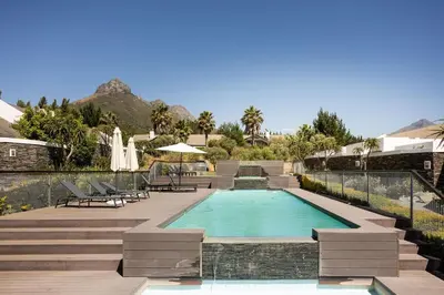 a swimming pool in a resort with stairs and chairs at Winelands Luxury Unit in Stellenbosch