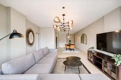 a living room with a couch and a tv at Belina - Knightsbridge Prestige Suite in Cape Town