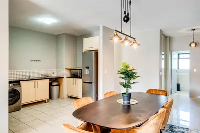 a kitchen and dining room with a table and chairs at Belina - Knightsbridge Prestige Suite in Cape Town