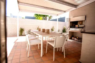a kitchen and dining room with a white table and chairs at Tide & Together in Hermanus