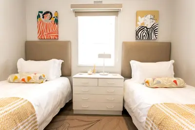 a bedroom with two beds and a window at Tide & Together in Hermanus
