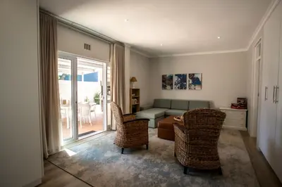 a living room with a couch and a table and chairs at Tide & Together in Hermanus