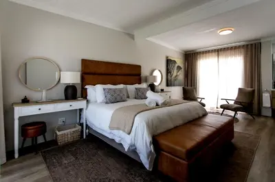 a bedroom with a large bed and a mirror at Tide & Together in Hermanus