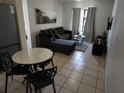 a living room with a couch and a table at Stepney Apartment in Cape Town