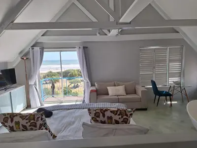 a living room with a couch and a large window at Salted in Cape Town