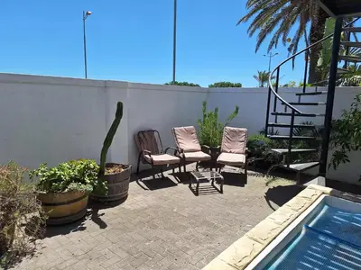 a patio with two chairs and a swimming pool at Salted in Cape Town