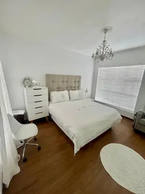 a bedroom with a bed and a chair and a dresser at Luxury Beach Front Apartment in Strand