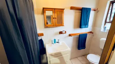 a bathroom with a sink and a toilet and a mirror at Casa Kari in Brackenfell