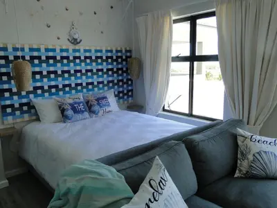a bedroom with a bed and a couch at Fresh Air in Cape Town