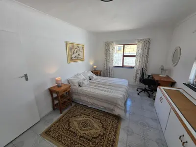 a bedroom with a bed and a desk and a window at Alvera in Strand