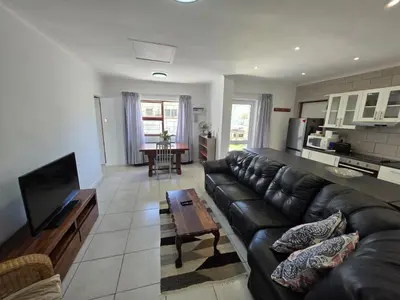 a living room with a black leather couch and a table at Alvera in Strand