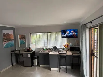 a kitchen with a tv hanging on the wall at Welcome Home in Somerset West