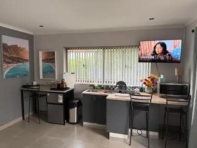 a kitchen with a tv hanging on the wall at Welcome Home in Somerset West