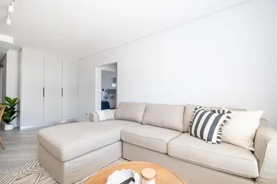 a white living room with a couch and a table at 113 Paarl 2 Bedroom Lux Aprt With Parking & Aircon in Paarl